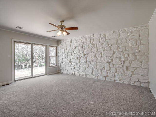 empty room featuring carpet flooring, a ceiling fan, visible vents, and ornamental molding