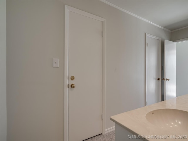 bathroom featuring crown molding and a sink