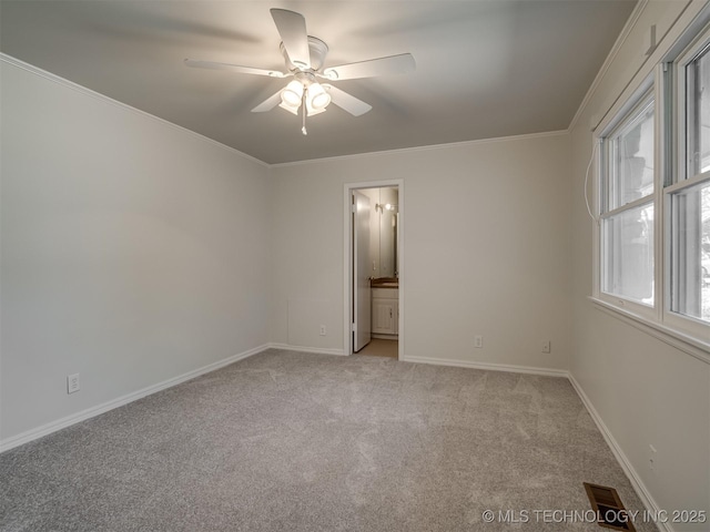 unfurnished room with baseboards, visible vents, ceiling fan, ornamental molding, and light colored carpet