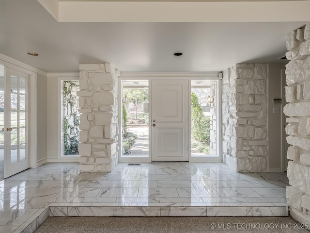 foyer featuring crown molding, french doors, and marble finish floor