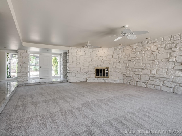 unfurnished living room with ceiling fan, a glass covered fireplace, and carpet flooring