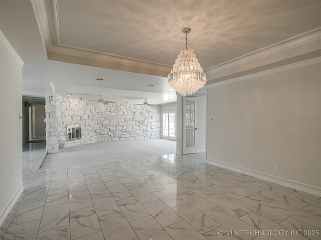 spare room featuring a stone fireplace, marble finish floor, crown molding, and a raised ceiling