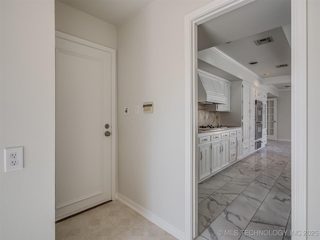 hall featuring baseboards, visible vents, and marble finish floor