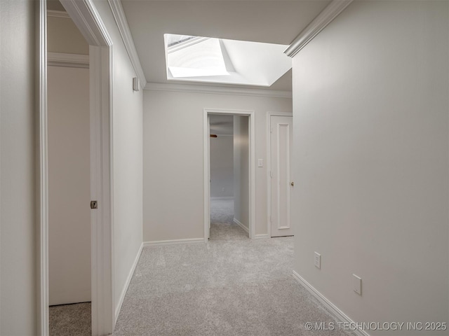 hall with baseboards, ornamental molding, and carpet flooring