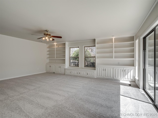 unfurnished living room featuring built in features, baseboards, carpet floors, and a ceiling fan