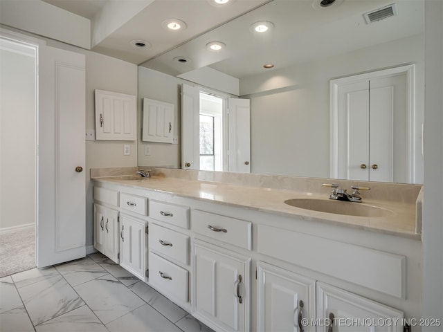 bathroom featuring visible vents, double vanity, recessed lighting, marble finish floor, and a sink