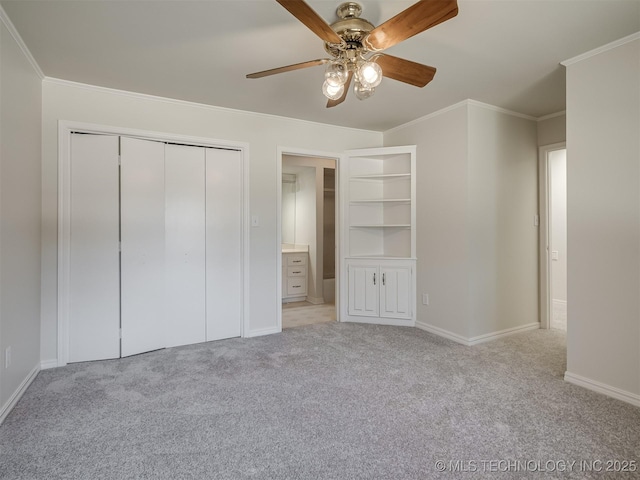 unfurnished bedroom featuring crown molding, baseboards, carpet floors, a closet, and a ceiling fan