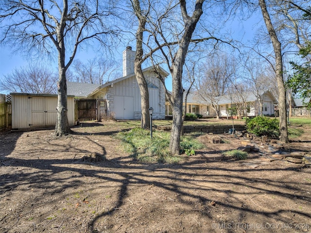 exterior space featuring a chimney and fence