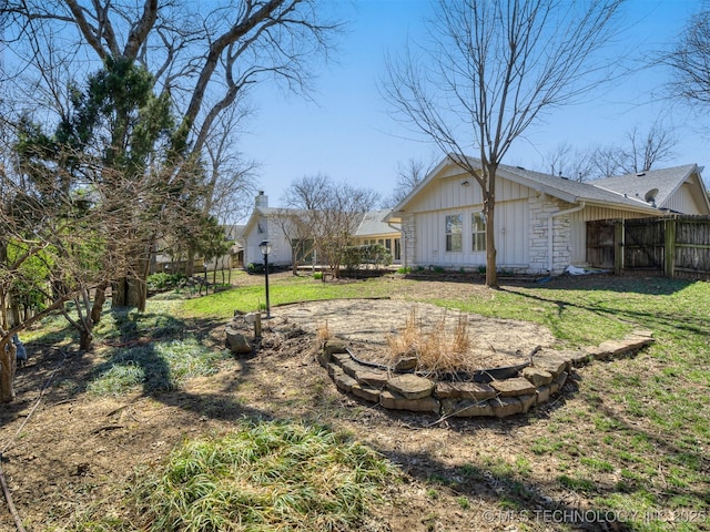 view of yard featuring an outdoor fire pit and fence