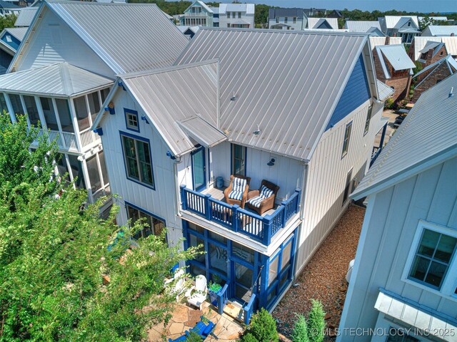 back of property featuring a sunroom and metal roof