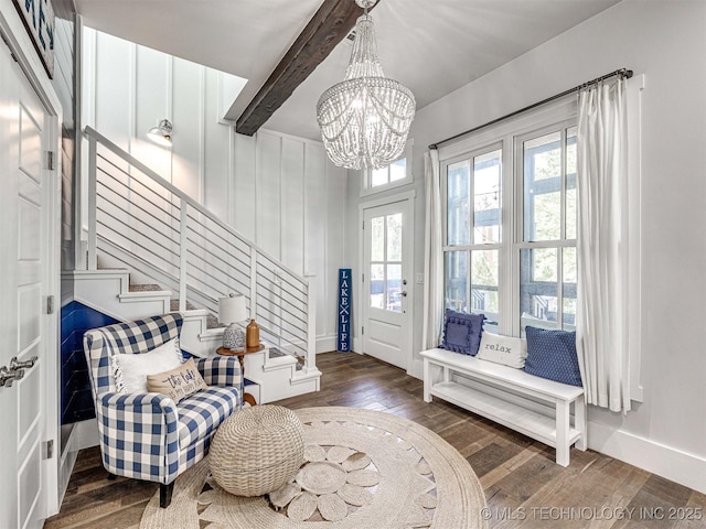 sitting room with beam ceiling, stairway, a chandelier, and wood finished floors