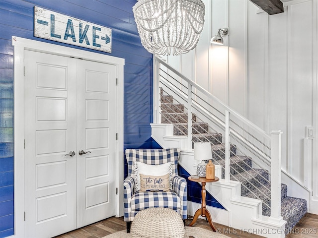 sitting room featuring stairway, a notable chandelier, and wood finished floors