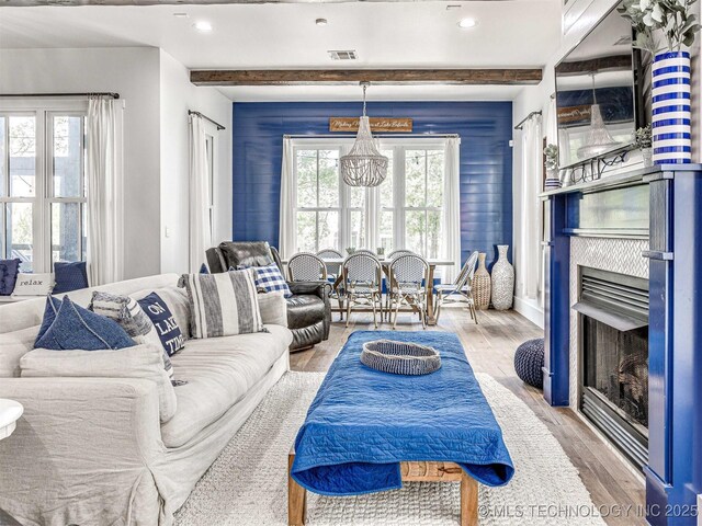 living room featuring visible vents, beam ceiling, wood finished floors, recessed lighting, and a fireplace