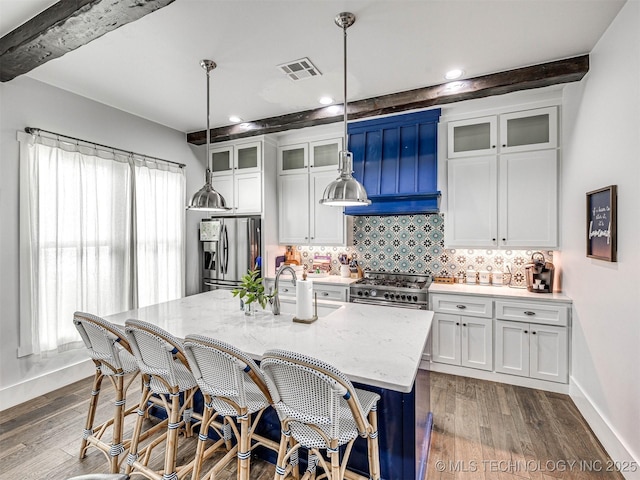 kitchen with visible vents, a sink, tasteful backsplash, dark wood finished floors, and appliances with stainless steel finishes