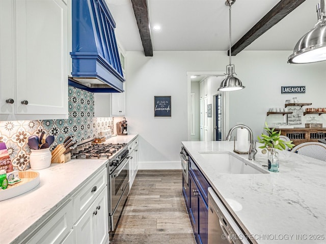 kitchen with premium range hood, beam ceiling, a sink, stainless steel appliances, and decorative backsplash