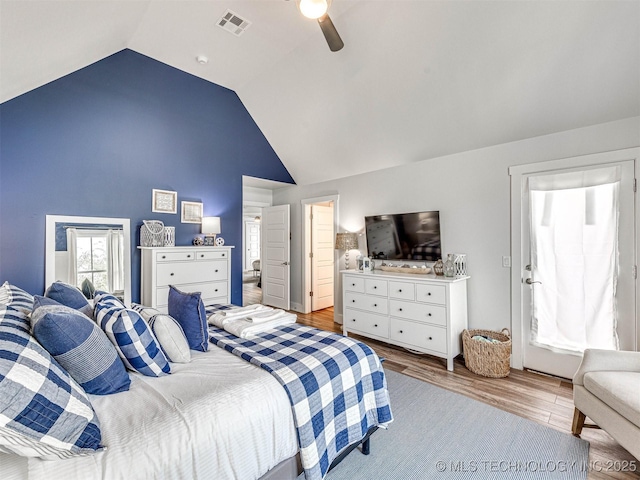 bedroom featuring a ceiling fan, wood finished floors, visible vents, and high vaulted ceiling