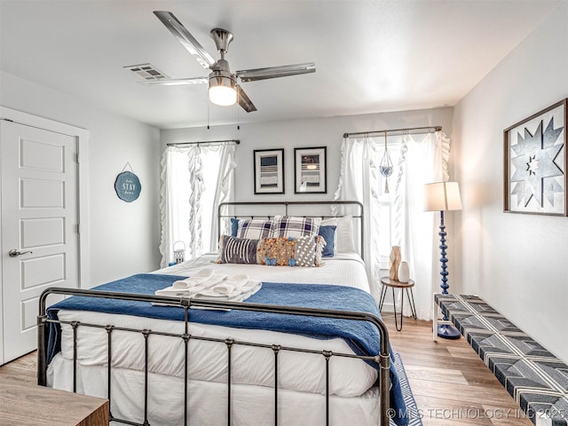 bedroom with visible vents, a ceiling fan, and light wood-style floors