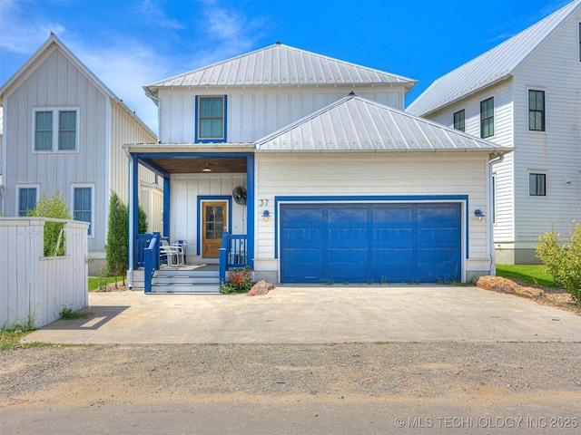 view of front of property featuring a porch, an attached garage, concrete driveway, board and batten siding, and metal roof