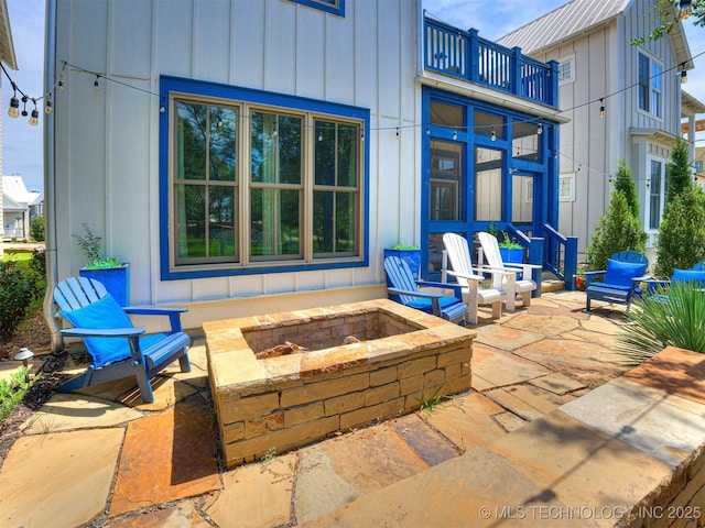 view of patio / terrace featuring a balcony and an outdoor fire pit