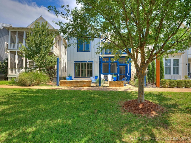 back of property featuring a lawn and board and batten siding