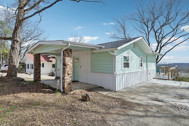 view of front of property featuring stone siding and driveway