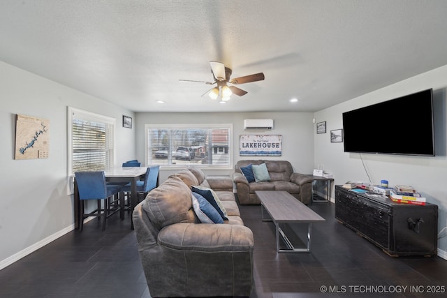 living room with ceiling fan, baseboards, an AC wall unit, recessed lighting, and a textured ceiling