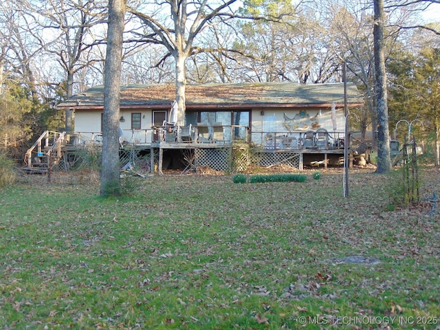 rear view of house with a lawn and a wooden deck