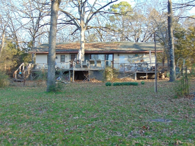 back of house with stairs, a deck, and a lawn