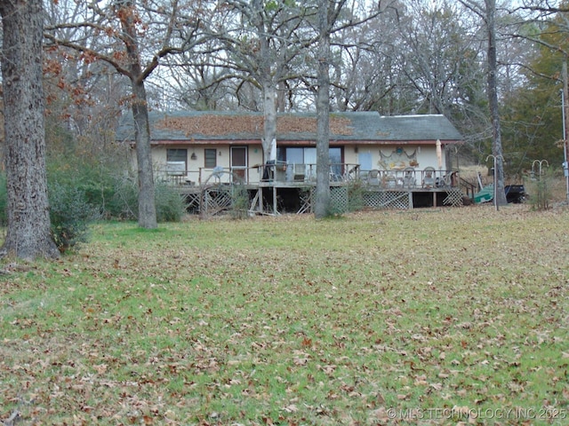 view of front of home featuring a front lawn and a wooden deck