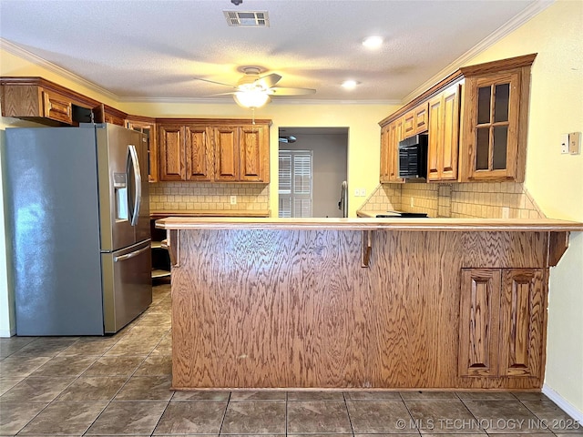 kitchen featuring visible vents, ornamental molding, glass insert cabinets, stainless steel refrigerator with ice dispenser, and black microwave