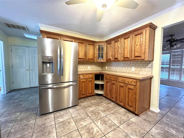 kitchen with visible vents, brown cabinets, decorative backsplash, and stainless steel fridge with ice dispenser