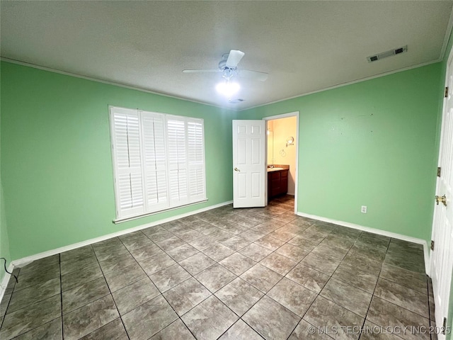 unfurnished bedroom featuring tile patterned floors, visible vents, ornamental molding, baseboards, and ceiling fan