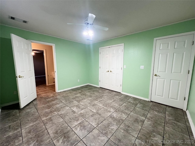 unfurnished bedroom featuring visible vents, a ceiling fan, a closet, crown molding, and baseboards