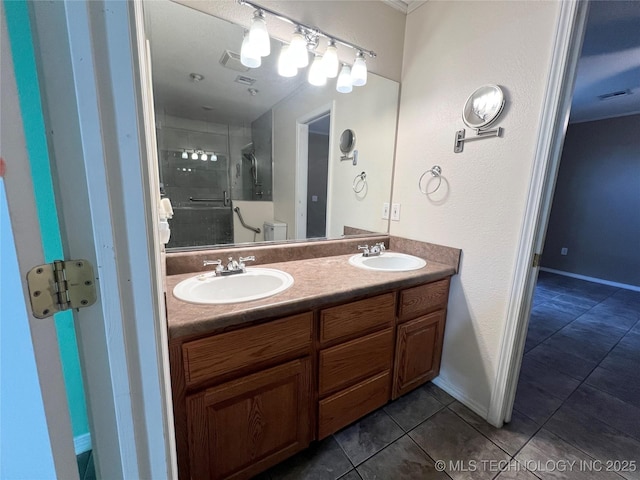 bathroom featuring tile patterned flooring, visible vents, a shower stall, and a sink