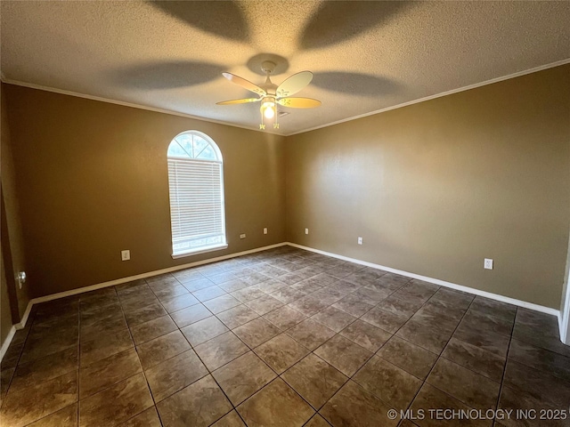 spare room with crown molding, baseboards, ceiling fan, dark tile patterned floors, and a textured ceiling