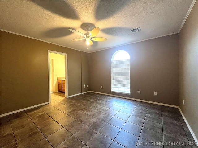 empty room with dark tile patterned flooring, a ceiling fan, visible vents, and ornamental molding