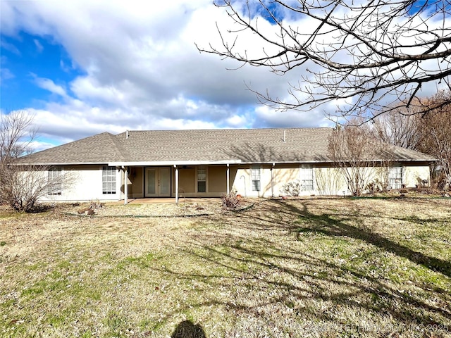 back of property featuring a shingled roof, a patio, a lawn, and stucco siding