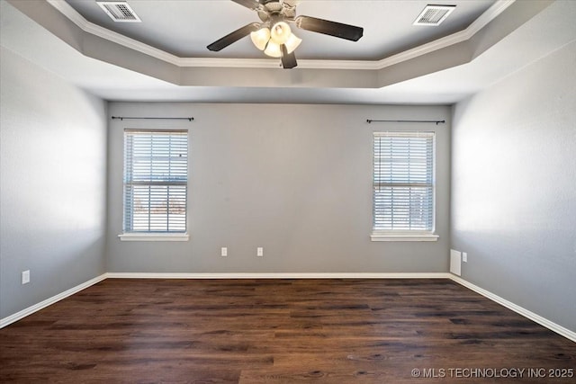 unfurnished room with visible vents, a raised ceiling, and a healthy amount of sunlight