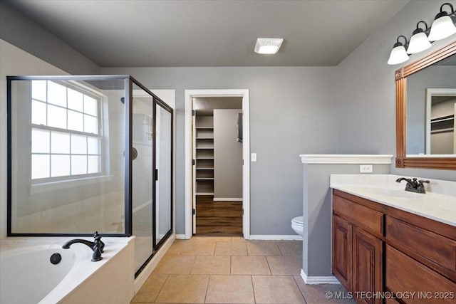 bathroom featuring a shower stall, a walk in closet, a bath, tile patterned floors, and vanity