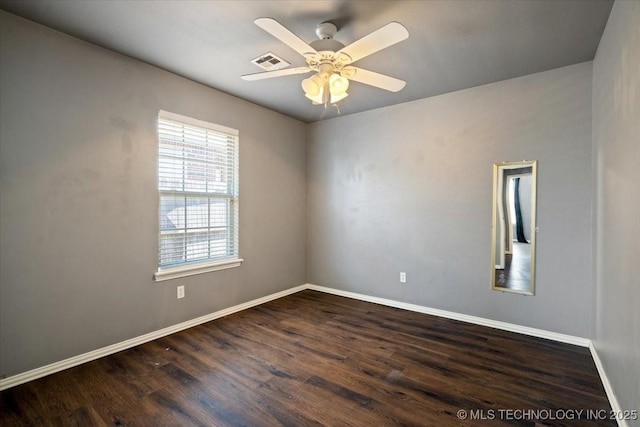 spare room featuring visible vents, baseboards, dark wood-type flooring, and a ceiling fan