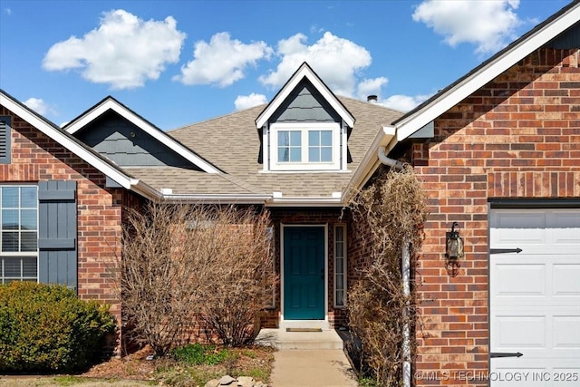 property entrance with brick siding, a garage, and roof with shingles