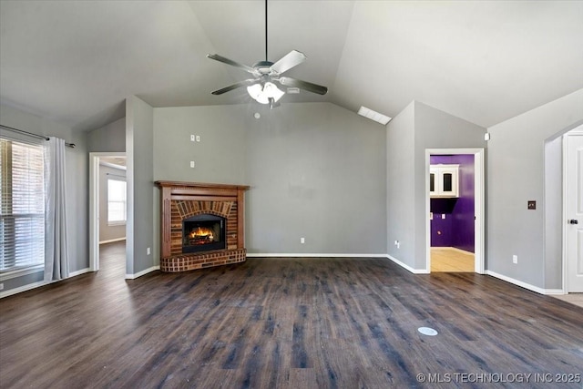 unfurnished living room featuring a brick fireplace, baseboards, lofted ceiling, and wood finished floors