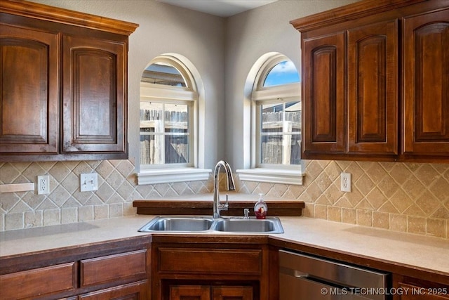 kitchen with a sink, tasteful backsplash, dishwasher, and light countertops