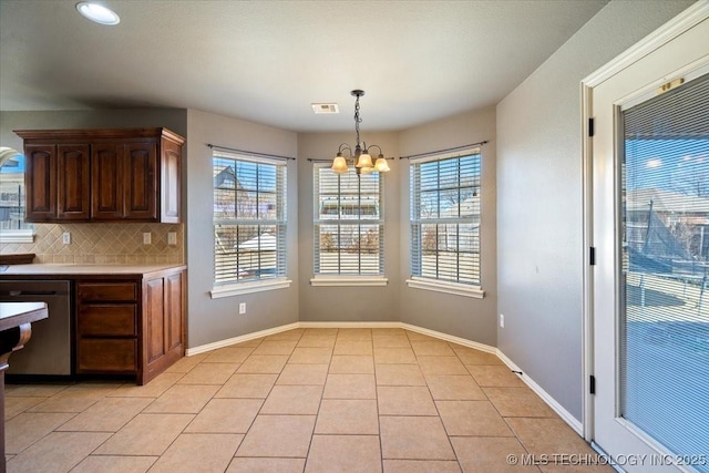 unfurnished dining area with light tile patterned floors, visible vents, an inviting chandelier, and a healthy amount of sunlight