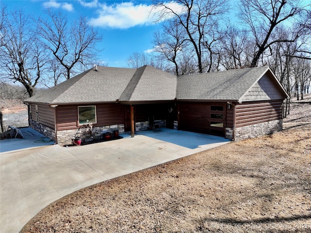 view of side of property featuring stone siding, faux log siding, and a shingled roof