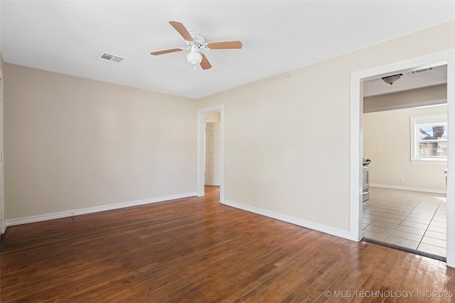 empty room featuring visible vents, baseboards, a ceiling fan, and hardwood / wood-style flooring