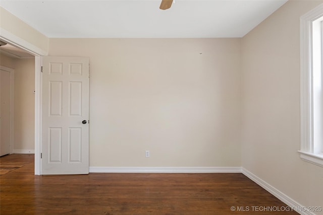 spare room with baseboards, wood finished floors, and a ceiling fan