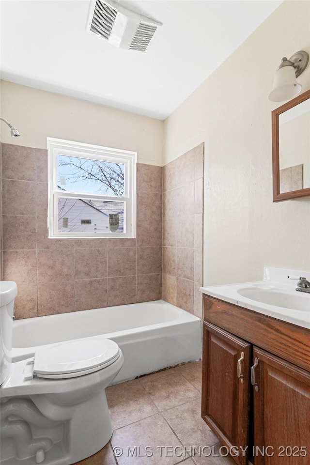 bathroom with vanity, visible vents, tile patterned floors, toilet, and a bathtub