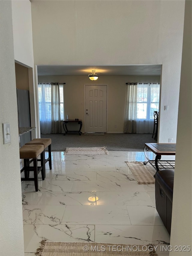 foyer entrance with a high ceiling and marble finish floor