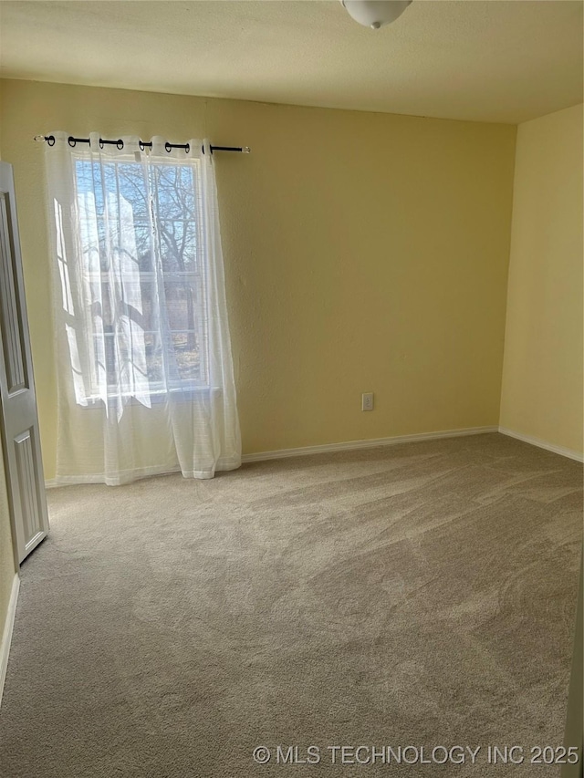 carpeted empty room with baseboards